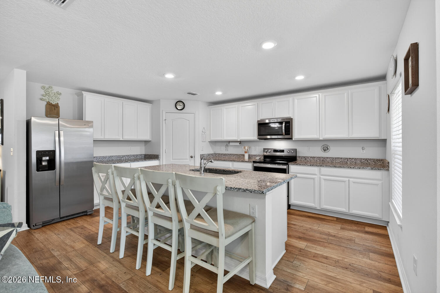 2 Radium Lane Palm Coast, FL 32164 - Photo 9 of 22 a kitchen with stainless steel appliances granite countertop a stove a sink a microwave a refrigerator and white cabinets with wooden floor