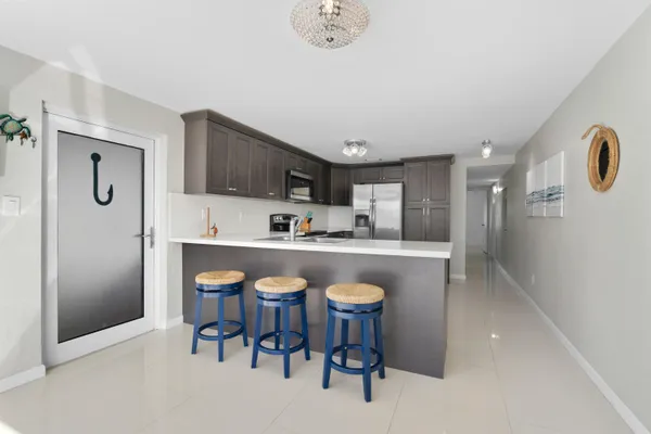 a kitchen with stainless steel appliances granite countertop a stove top oven a sink dishwasher and a microwave oven on the blue kitchen countertops