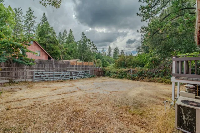 a view of an house with backyard and trees