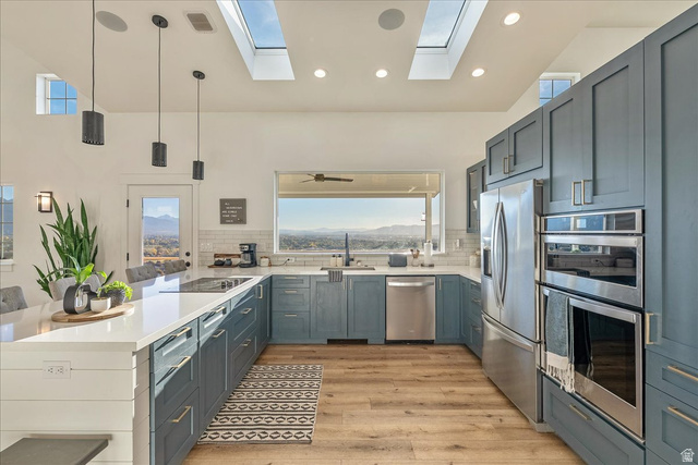 1800 Spring Oaks Drive Springville, UT 84663 - Photo 15 of 68 Kitchen with decorative light fixtures, stainless steel appliances, a peninsula, light wood-type flooring, and light stone countertops