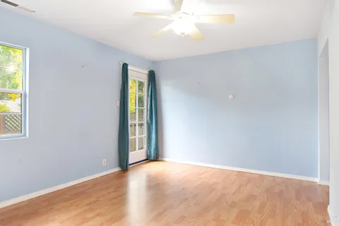 an empty room with a window and wooden floor