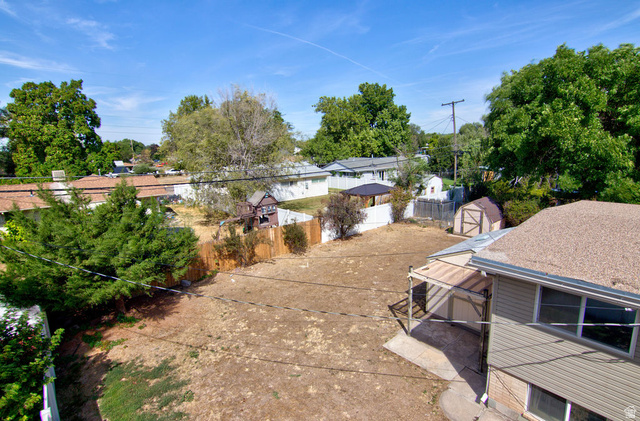 669 Colonial Avenue Layton, UT 84041 - Photo 35 of 51 Expansive backyard with a storage shed, covered patio, and a privacy fence