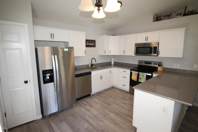 a kitchen with a sink a refrigerator a microwave and cabinets