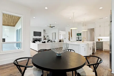 a living room with stainless steel appliances furniture and a kitchen view