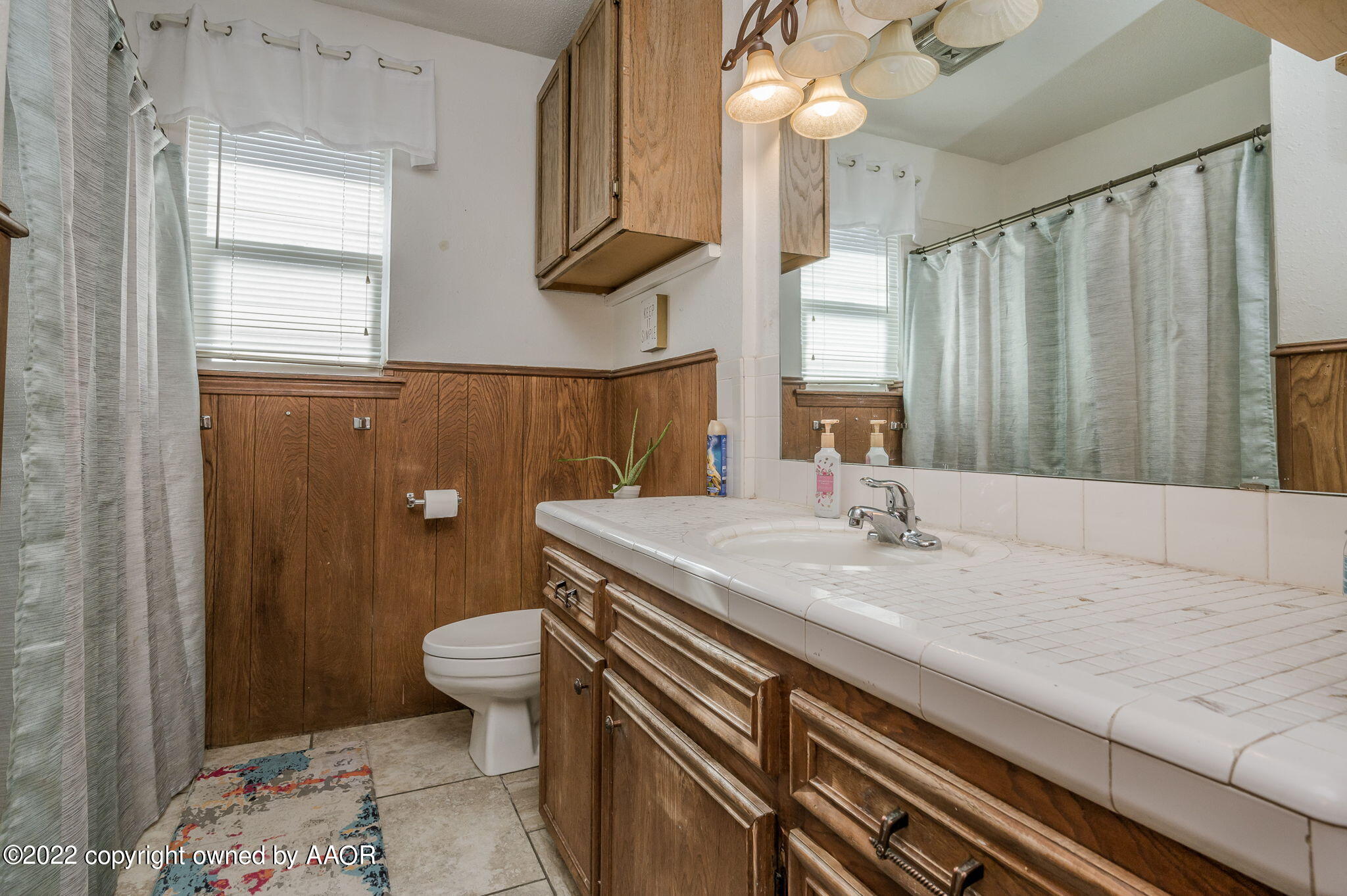 5110 Shawnee Trail Amarillo, TX 79109 - Photo 18 of 22 a bathroom with a granite countertop sink a toilet and a mirror