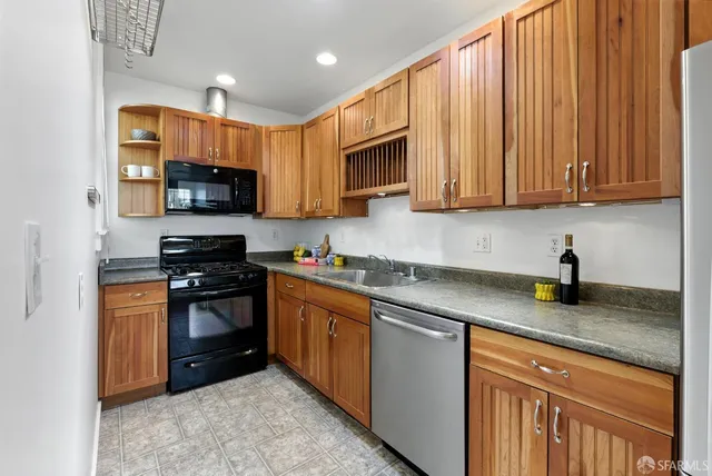 a kitchen with granite countertop a sink dishwasher and cabinets