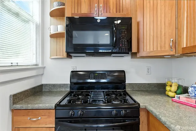 a kitchen with granite countertop white cabinets and refrigerator