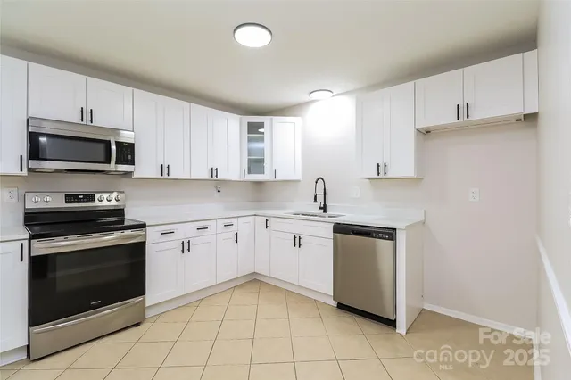 a kitchen with cabinets stainless steel appliances and a sink