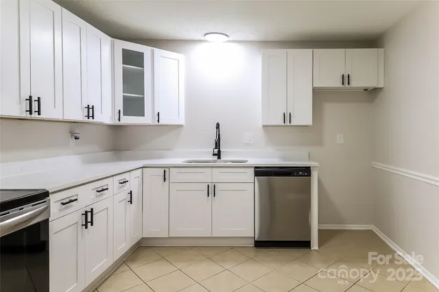 a kitchen with granite countertop white cabinets and stainless steel appliances