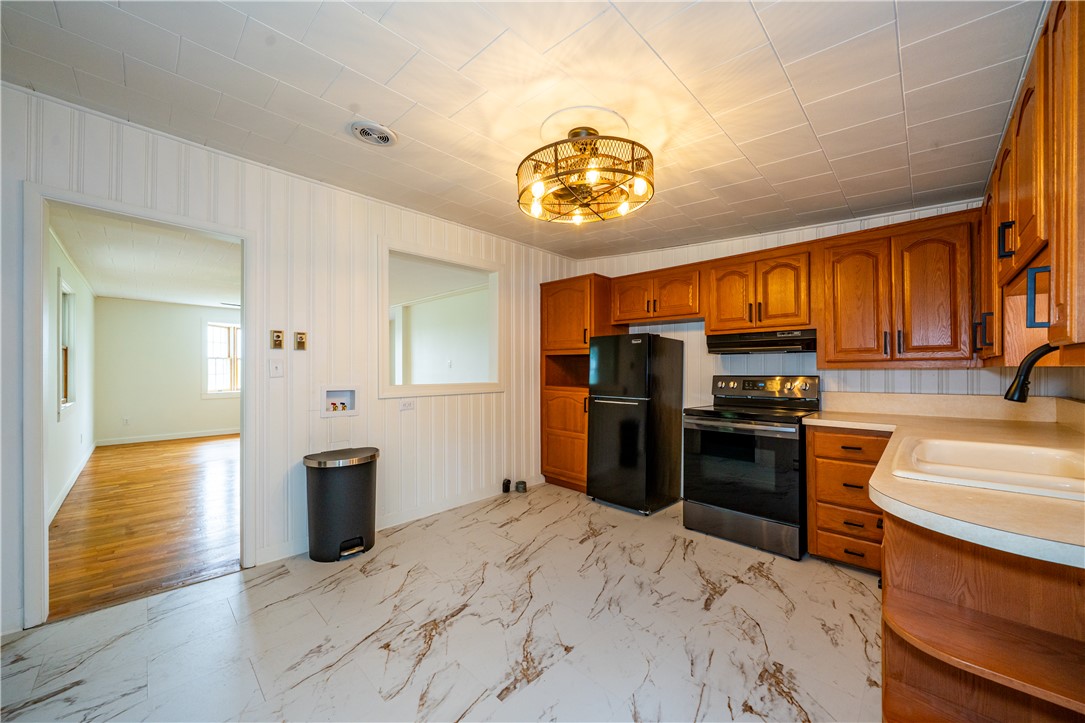 11296 Pansing Road Brookville, OH 45309 - Photo 12 of 53 This kitchen offers functional design with warm wood cabinetry and durable flooring, ideal for everyday living.