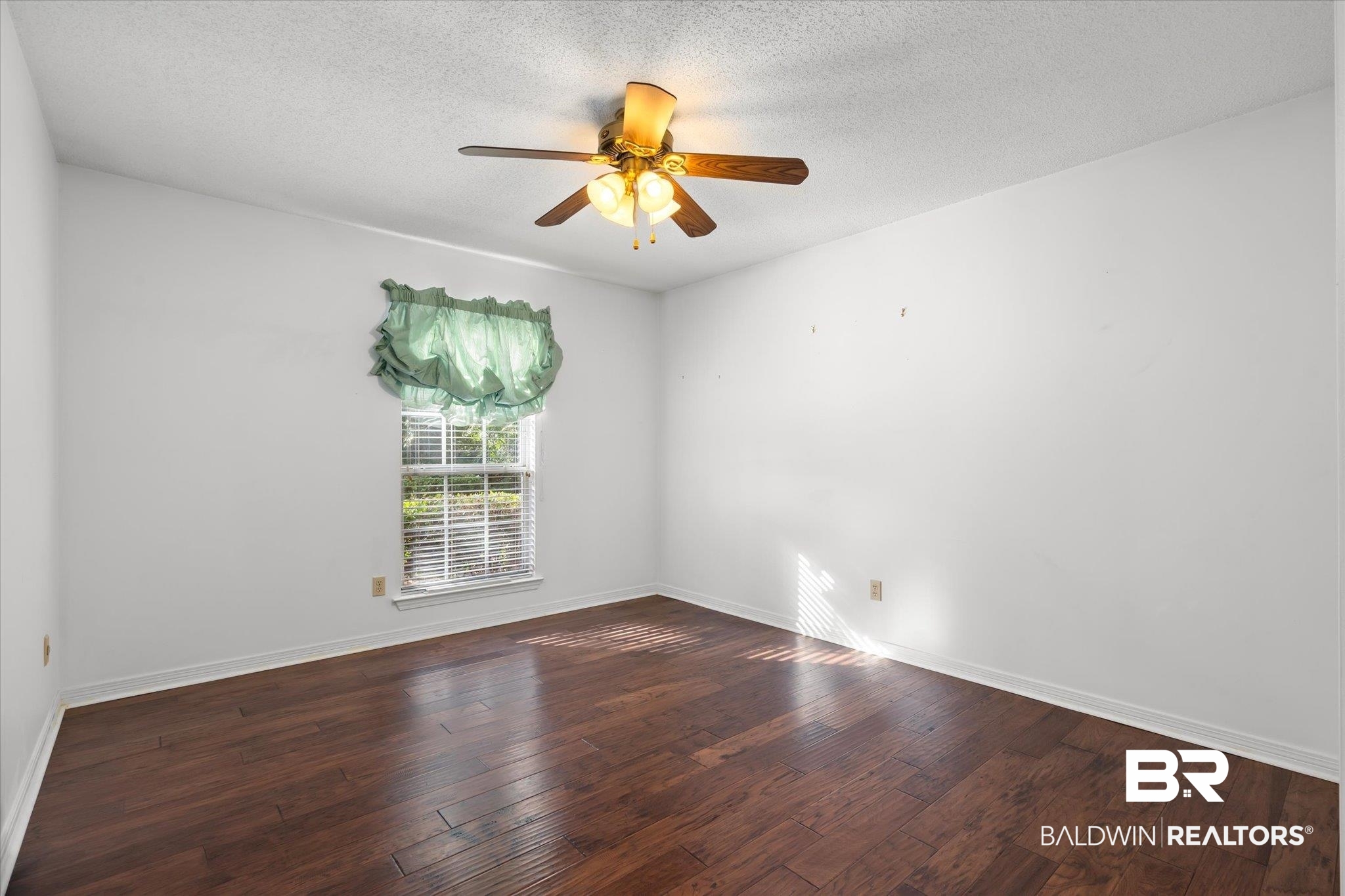 7410 East Lakeview Drive Mobile, AL 36695 - Photo 10 of 20 Empty room featuring a textured ceiling, ceiling fan, and dark hardwood / wood-style floors