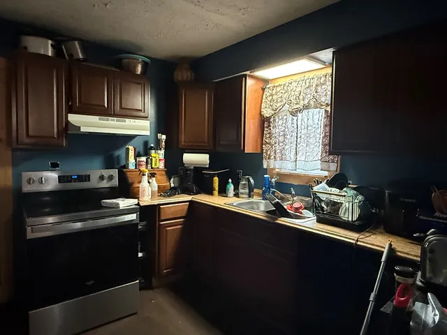 a kitchen with a sink a stove a refrigerator and cabinets