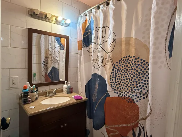 a bathroom with a sink mirror and a toilet