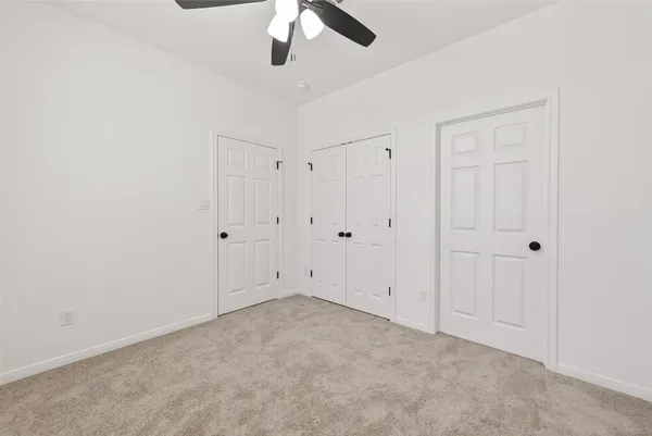 an empty room with chandelier fan