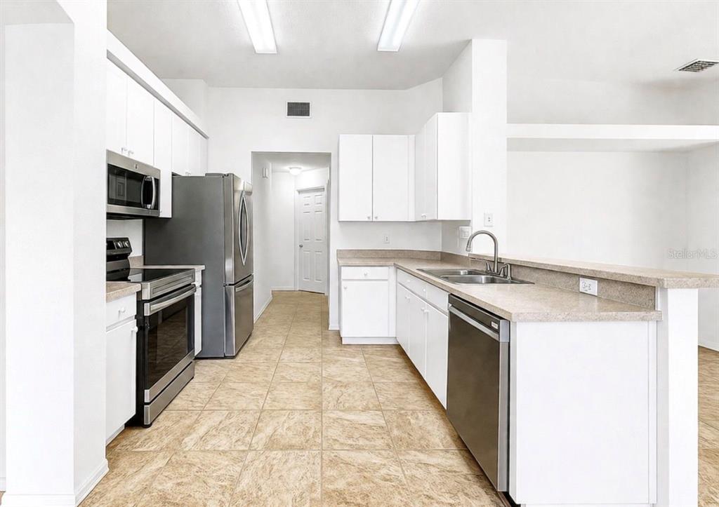 10725 Deepbrook Drive Riverview, FL 33569 - Photo 19 of 67 a kitchen with a stove a sink and a refrigerator