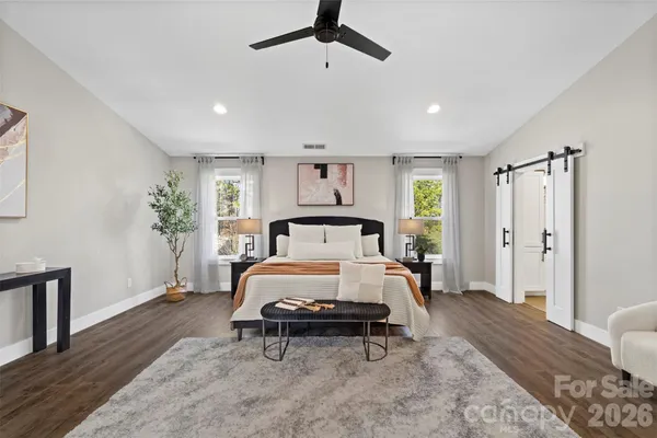 a spacious bedroom with a bed a couch and a window