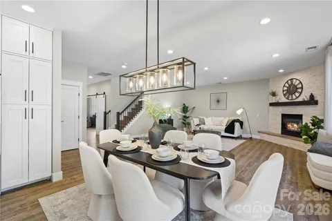 a dining room with furniture a chandelier and wooden floor