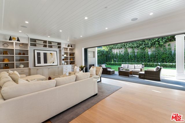 a living room with furniture garden view and a floor to ceiling window