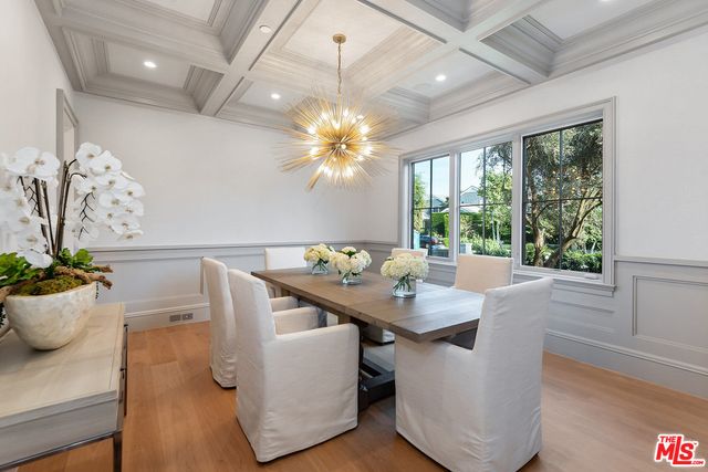 a dining room with furniture a potted plant and a chandelier