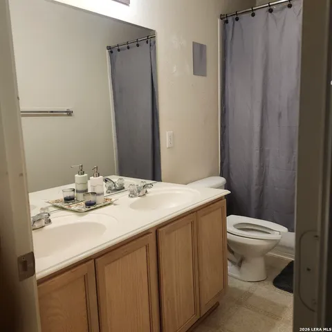 a bathroom with a sink a toilet a shower a vanity and a mirror