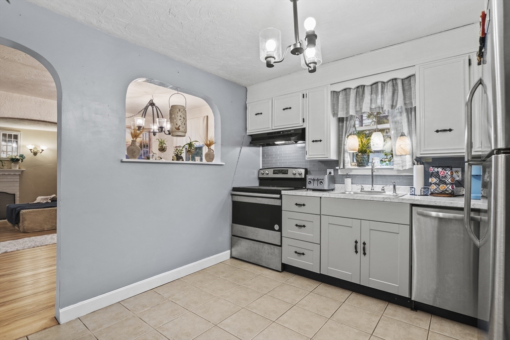 170 Stafford Street Worcester, MA 01603 - Photo 5 of 29 a kitchen with stainless steel appliances a stove refrigerator and a window
