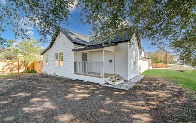 a view of a house with backyard and a tree