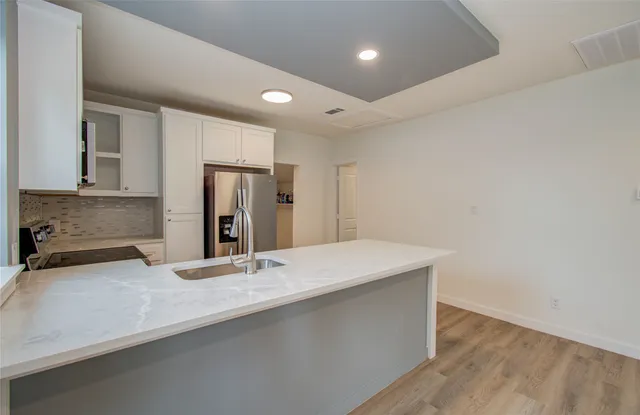 a kitchen with stainless steel appliances kitchen island granite countertop a refrigerator and a stove top oven