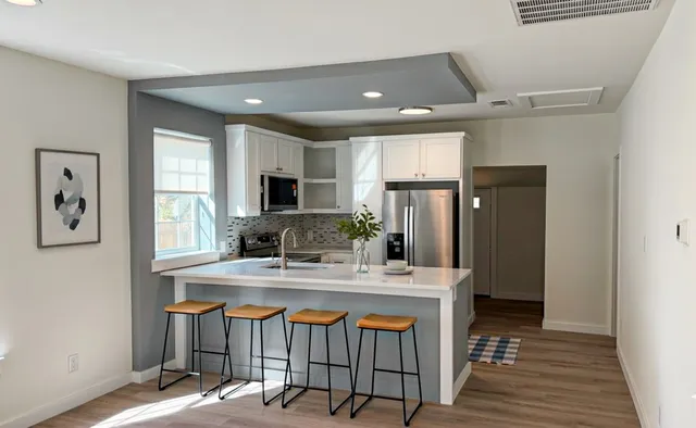 a kitchen that has a lot of cabinets a sink and a stove in it