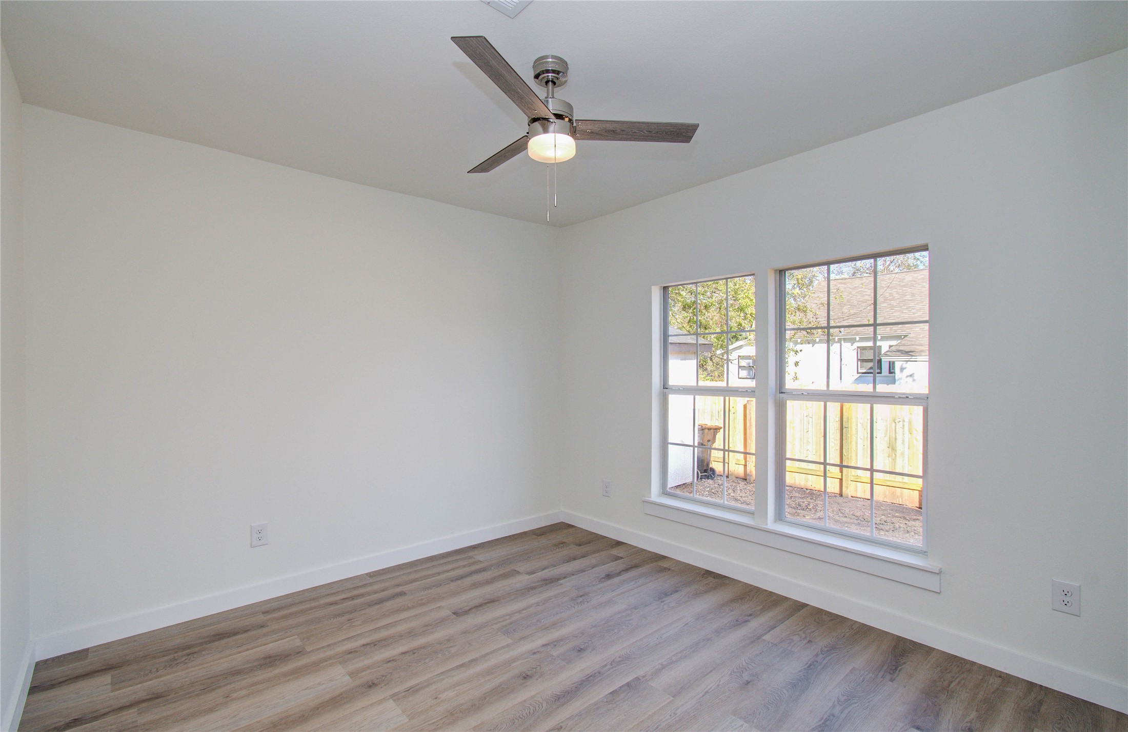 1301 Southgate Drive Rosenberg, TX 77471 - Photo 17 of 49 an empty room with wooden floor and windows