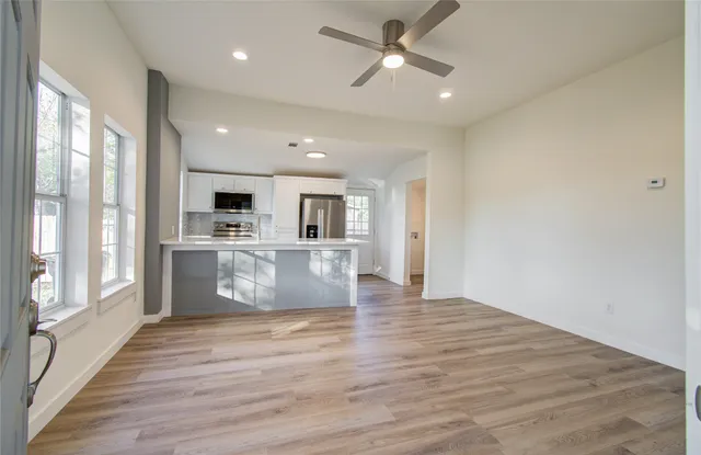 a kitchen with stainless steel appliances a sink a stove a refrigerator cabinets and a window