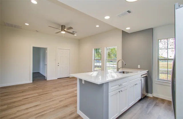 a kitchen with a sink appliances and wooden floor