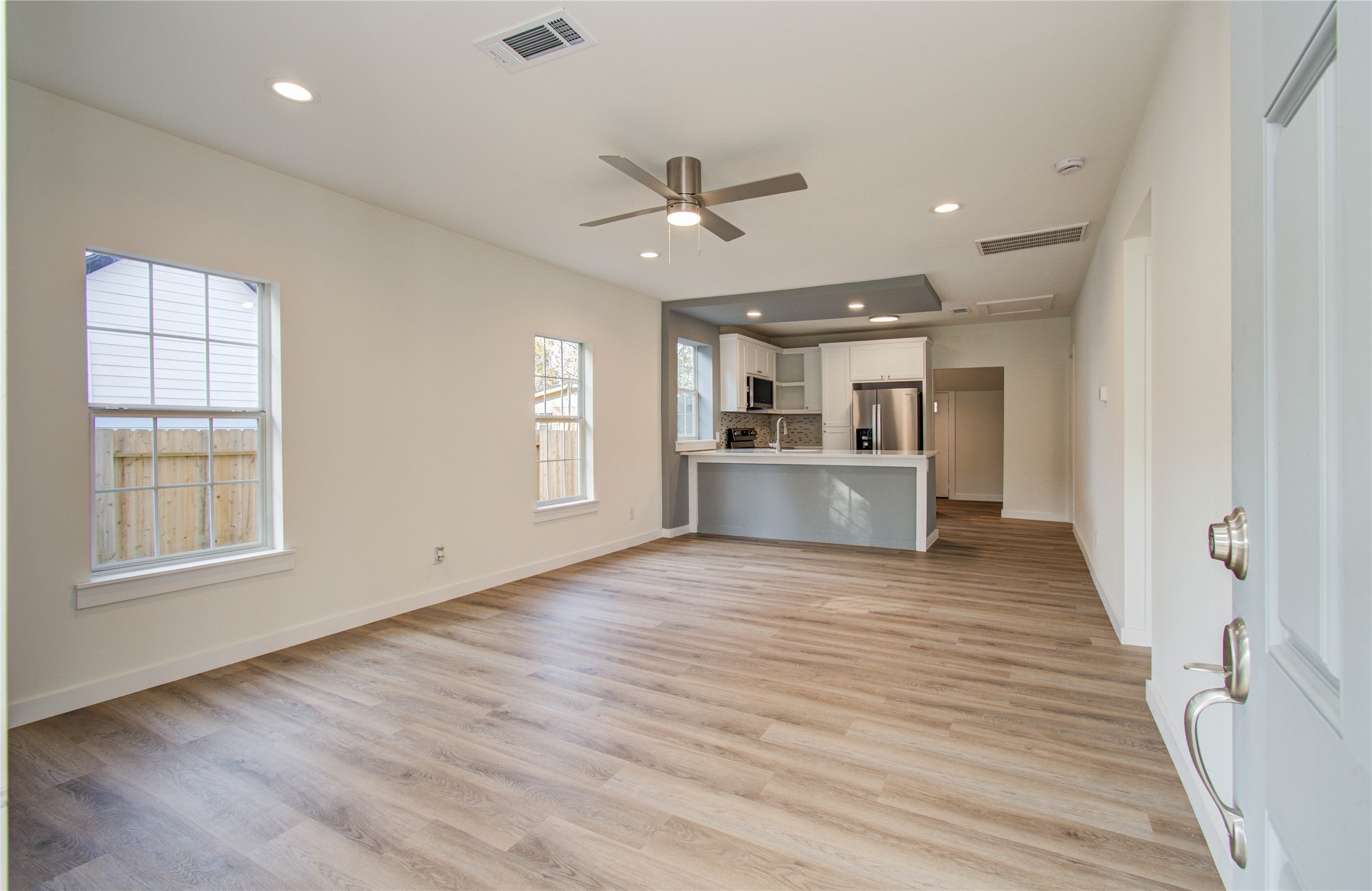 1301 Southgate Drive Rosenberg, TX 77471 - Photo 6 of 49 an empty room with wooden floor a ceiling fan and windows