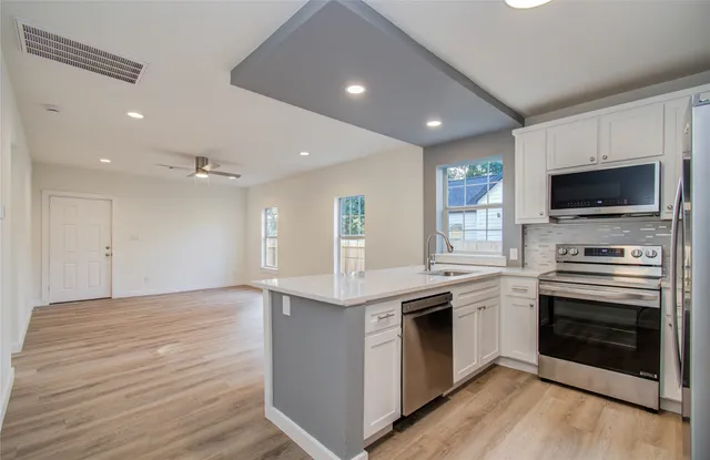 a kitchen with stainless steel appliances kitchen island granite countertop a stove top oven and sink