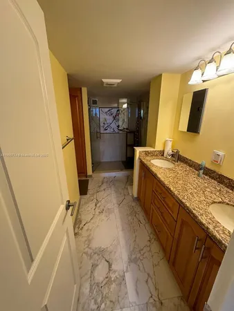 a bathroom with a granite countertop sink a mirror and a shower