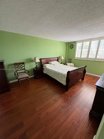 a bedroom with a bed and a wooden floor