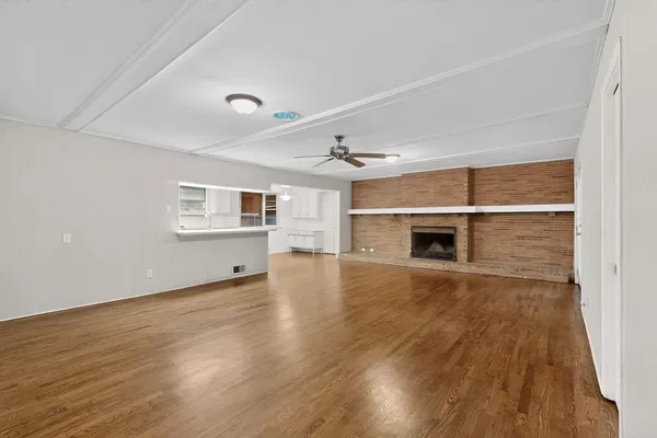 an empty room with wooden floor and fireplace