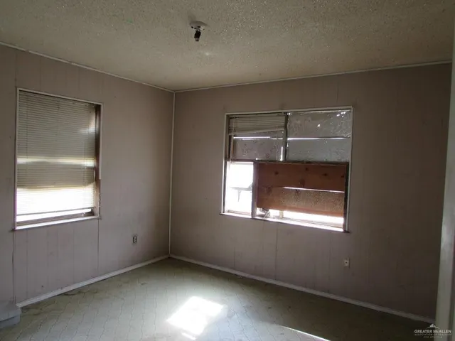 an empty room with windows and closet