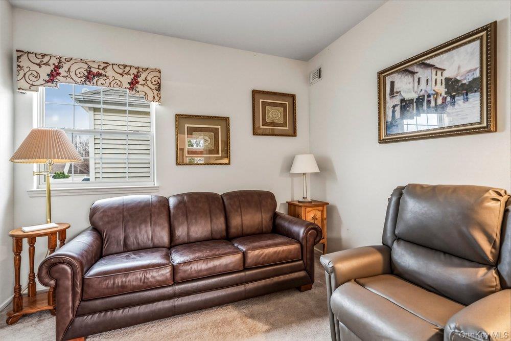587 Leisure Drive Ridge, NY 11961 - Photo 16 of 49 a blue couch sitting in a living room with a couch