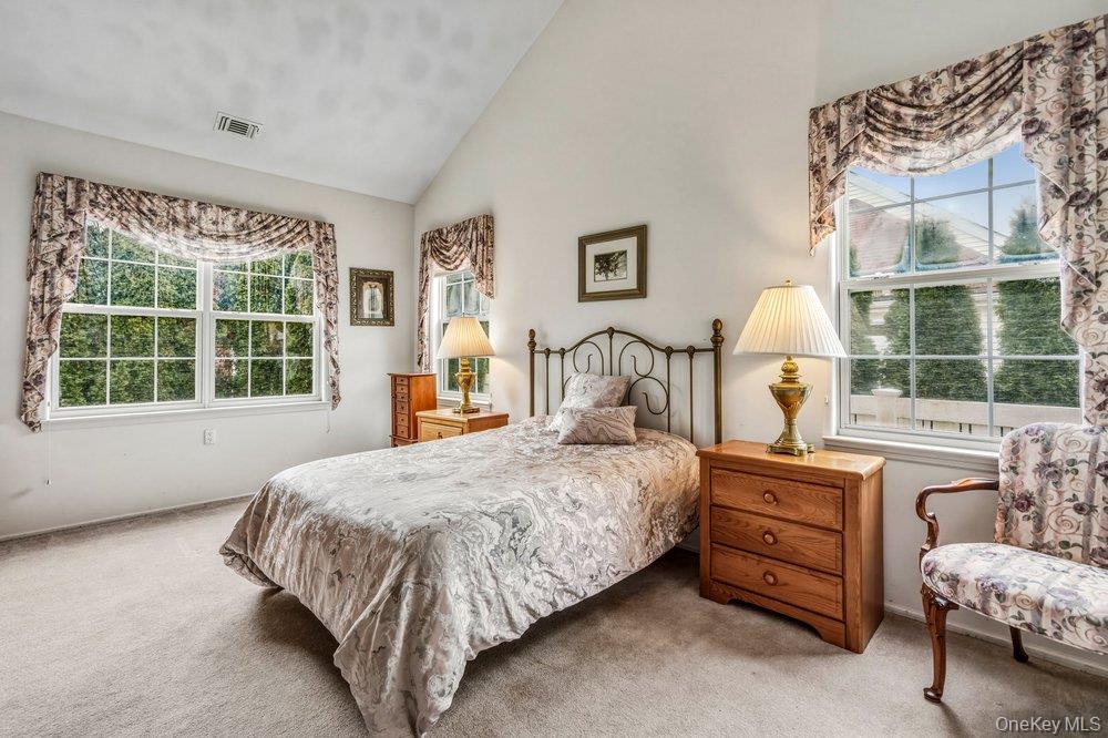 587 Leisure Drive Ridge, NY 11961 - Photo 18 of 49 a bedroom with a bed chair and window