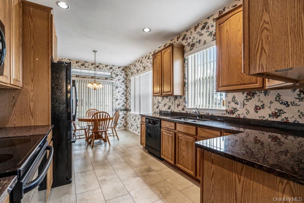 587 Leisure Drive Ridge, NY 11961 - Photo 24 of 49 a kitchen with granite countertop a sink stove and cabinets