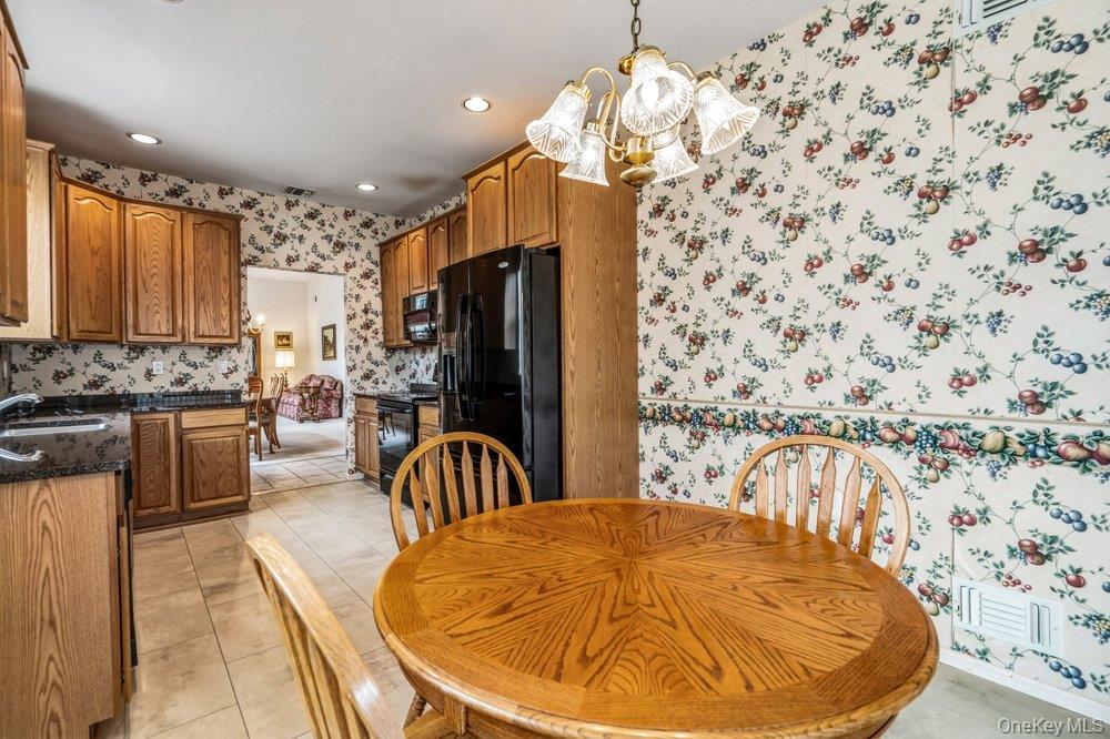 587 Leisure Drive Ridge, NY 11961 - Photo 29 of 49 a view of a kitchen with kitchen island stainless steel appliances a dining table and a chandelier