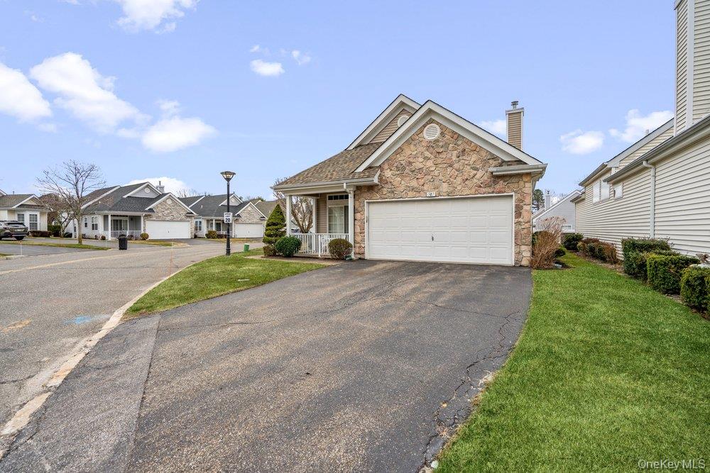 587 Leisure Drive Ridge, NY 11961 - Photo 3 of 49 a view of a house with a yard and garage