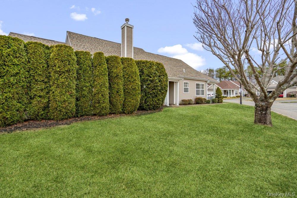 587 Leisure Drive Ridge, NY 11961 - Photo 41 of 49 a front view of a house with garden