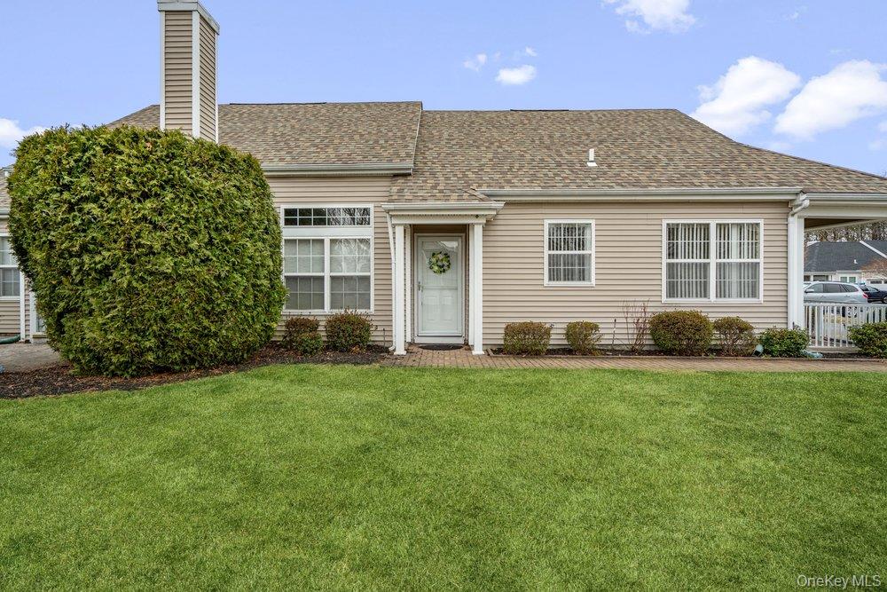 587 Leisure Drive Ridge, NY 11961 - Photo 5 of 49 a front view of a house with a garden