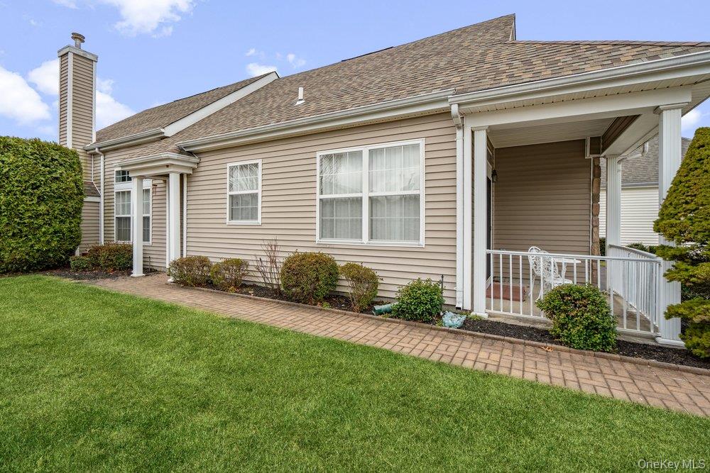 587 Leisure Drive Ridge, NY 11961 - Photo 6 of 49 a front view of a house with a yard and porch