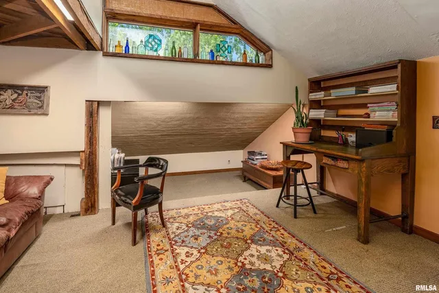 a bedroom with a bed a chair and next to a window