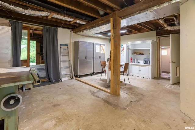 a bedroom with a bed and large windows
