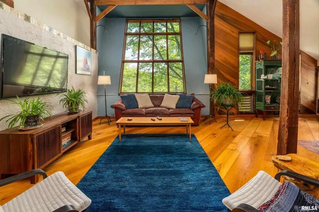 a living room with furniture a flat screen tv and a table