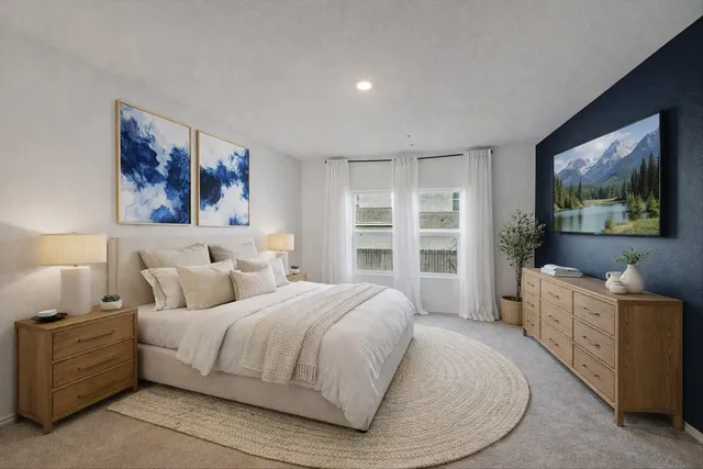 a spacious bedroom with a bed and a flat screen tv