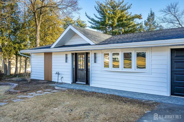 a view of kitchen and empty room with wooden floor